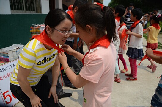 捐贈儀式上，孩子們?yōu)閻坌奶焓瓜瞪霞t領(lǐng)巾