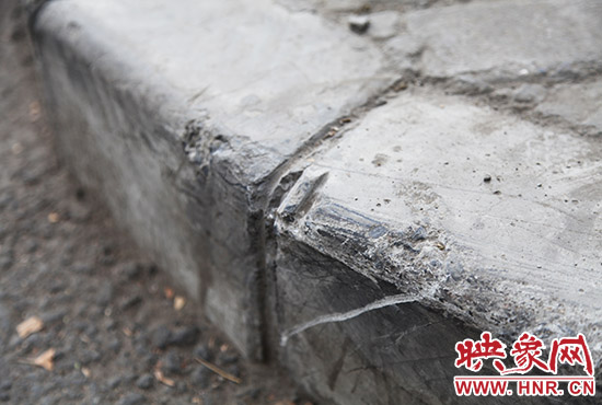 車道邊上的臺階，滿是電動車摔下碰撞的痕跡