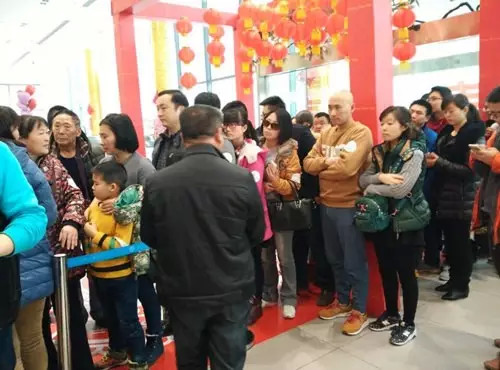 排隊領(lǐng)年貨，一家老小齊上陣。