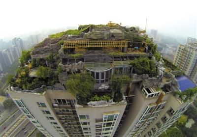 　　昨日，身穿橘黃色馬甲的工作人員在人濟(jì)山莊樓頂拆除違章建筑。新京報(bào)記者 吳江 攝