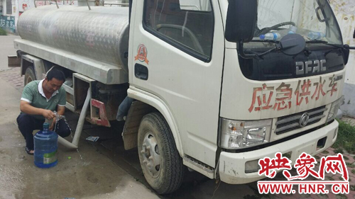 柘城縣黃山小區(qū)的居民，因?yàn)橥Ｋ?，只能接了自?lái)水再往樓上搬。