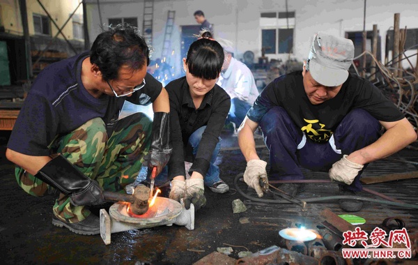 劉金玉正在和工友一起修理隔膜泵