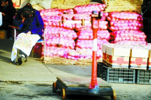 水果批發(fā)市場(chǎng)內(nèi)，沒(méi)有客戶時(shí)，商戶在繡十字繡