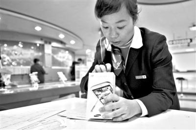 11月6日，北京移動西直門營業(yè)廳的工作人員在為顧客購買的4G手機登記。新華社發(fā)