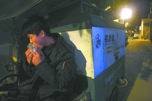 快遞哥抽空吃兩口東西。記者 李剛 攝