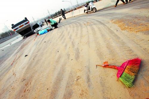 被撞的環(huán)衛(wèi)工躺在地上，身上蓋著藍色布塊，現(xiàn)場除散落的汽車碎片外，還留有被撞斷的掃帚。