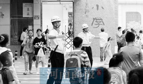 伊河路小學(xué)門口，兩名巡防隊員護送學(xué)生過馬路