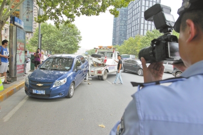 在金水路，交警對在機動車道違法停放的車輛施行拖離