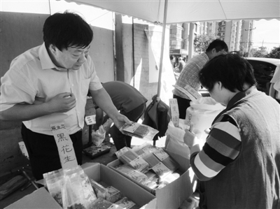 昨日，河南企業(yè)家劉春喜在京“練攤”，為顧客挑選綠豆。新京報(bào)記者 張玉學(xué) 攝