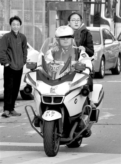 7日，首爾，警察將一名考生送抵考場。新華社發(fā)