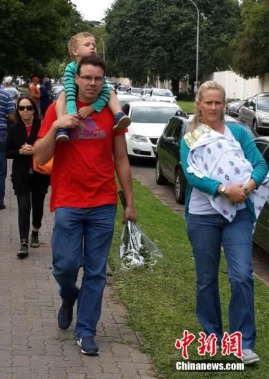 圖為一個白人家庭，由父母帶著孩子到曼德拉家門外悼念。中新社發(fā) 宋方燦 攝