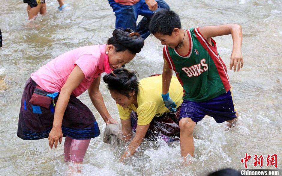 7月9日，村民在小河里摸魚搶魚。譚凱興 攝