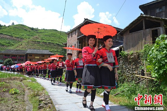 圖為新娘身著瑤族盛裝在伴娘和親友的陪伴下“出嫁”。中新社發(fā) 韋吉陽 攝