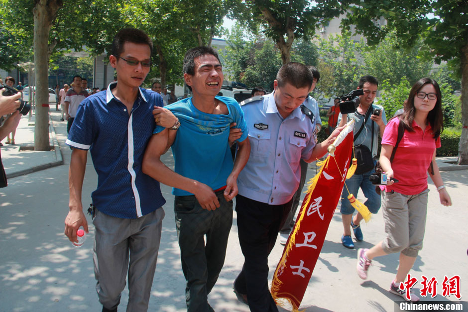 圖為獲救嬰兒父親情緒一度失控，當(dāng)?shù)鼐焦ぷ魅藛T對(duì)其進(jìn)行攙扶。張一辰 攝