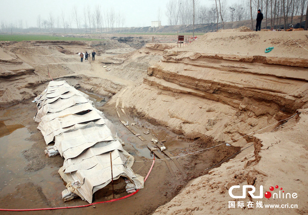2014年1月6日，河南洛陽古沉船發(fā)掘現(xiàn)場，近日有雨雪天，考古人員給古沉船披上一層“雨衣”。