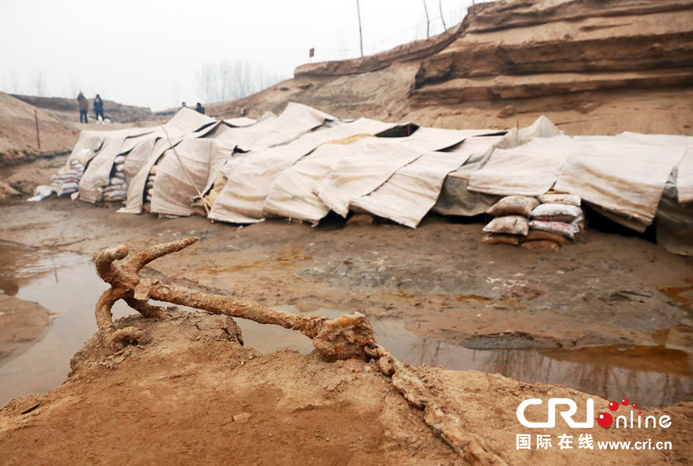 2014年1月6日，河南洛陽古沉船發(fā)掘現(xiàn)場，古沉船鐵錨從見天日，靜靜地躺在古船旁。