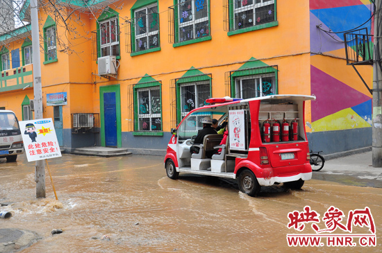 巡防隊員將巡消車開到對面，將上學(xué)的小朋友一個一個接上車，送出家屬院