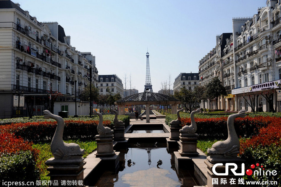 　2014年3月21日，杭州天都城，農(nóng)民在山寨埃菲爾鐵塔下耕作。圖片來(lái)源：東方IC