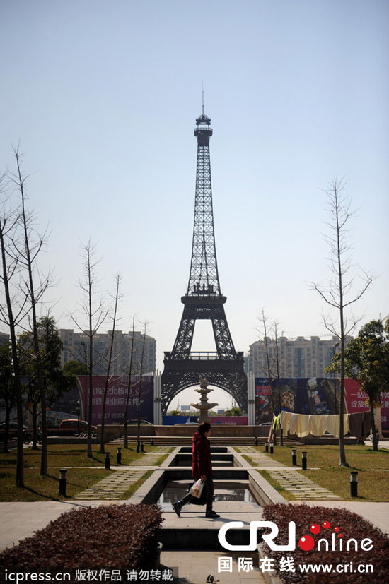 　2014年3月21日，杭州天都城，農(nóng)民在山寨埃菲爾鐵塔下耕作。圖片來(lái)源：東方IC