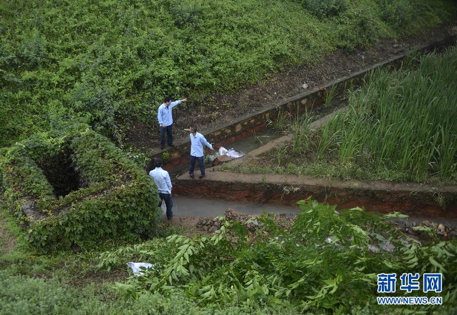5月18日，工作人員在槽罐車泄漏現(xiàn)場(chǎng)附近的水渠邊查看情況。