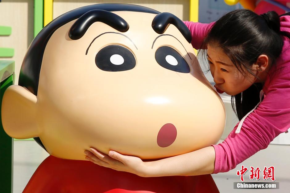 4月22日，游客與蠟筆小新合影?！跋灩P小新25周年紀(jì)念特展”日前在北京開展，吸引了不少市民游客。