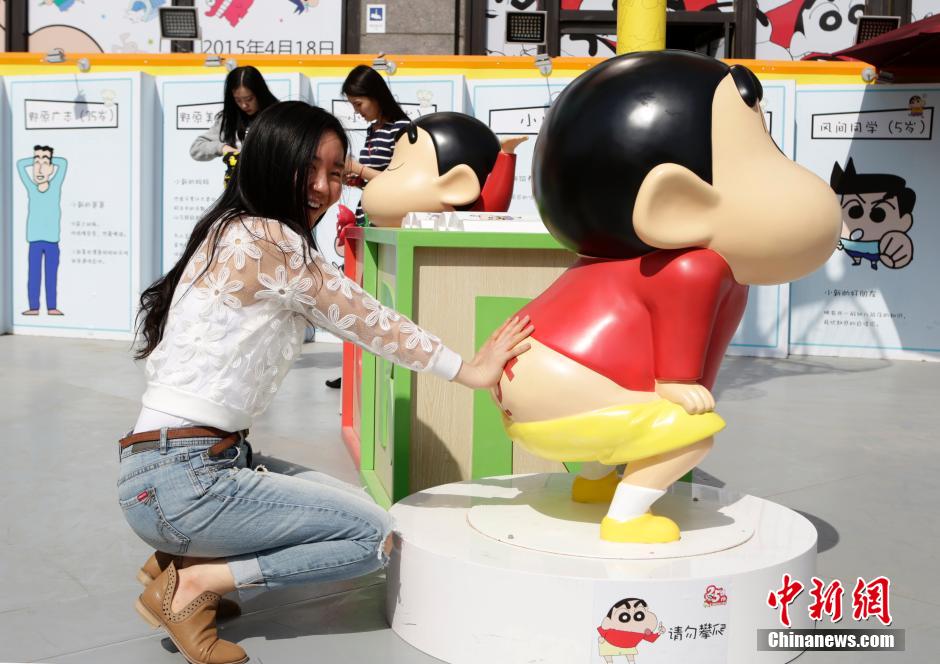 4月22日，游客與蠟筆小新合影?！跋灩P小新25周年紀(jì)念特展”日前在北京開展，吸引了不少市民游客。