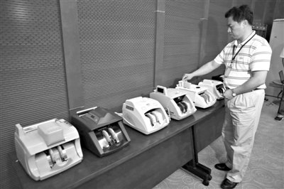 昨日，央行工作人員用各種驗(yàn)鈔機(jī)對(duì)C1F9假幣進(jìn)行測(cè)試，機(jī)器均能及時(shí)作出異常報(bào)警反應(yīng)。新京報(bào)記者 浦