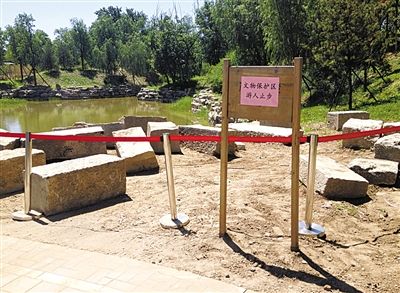 圓明園規(guī)月橋橋體構(gòu)件區(qū)域的警戒線和提示牌。 新京報記者 鄧琦 攝