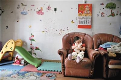 6月14日，未婚媽媽于軍的家里。女兒悅悅抱著兔子玩偶，在聽(tīng)媽媽手機(jī)上的兒歌，這個(gè)4歲女孩喜歡兔子。