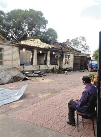 7月27日，海倫聯(lián)合敬老院內(nèi)，幾名老人看著對(duì)面被燒毀的特護(hù)病房。新京報(bào)記者 涂重航 攝