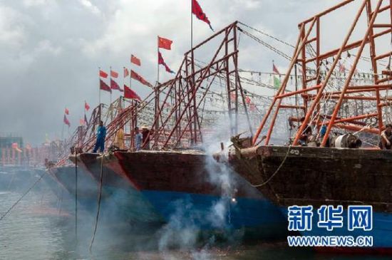 2013年8月1日 南海開漁日 臨高迎新港 8月1日，海南省臨高縣漁民在船上鳴放鞭炮慶祝武蓮港開港。