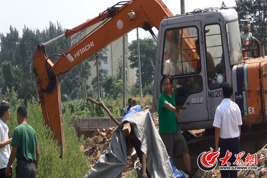 陳寶成手持自制刀斧守在挖掘機旁阻止便衣民警靠前。（視頻截圖）