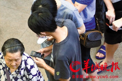 排隊(duì)的“黃?！备魇謭?zhí)一疊白紙，上面寫好了要掛號(hào)的人的信息，包括姓名、電話、要掛的科室等。穿黑白花紋衣服的老婆婆正在排隊(duì)掛號(hào)