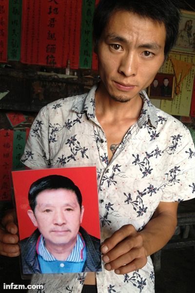 程興貴的兒子程正鵬拿著父親的遺照。程興貴自殺后，政府補償程家6000多塊錢，并終于認(rèn)定了程興貴的代課教齡。 (南方周末記者雷磊/圖)