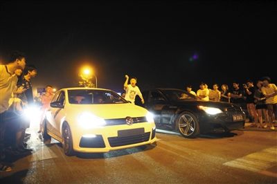 8月24日晚，東壩中街飆車現(xiàn)場，兩輛車并排等待出發(fā)指令，旁邊許多愛好者前來觀看比賽。新京報(bào)記者