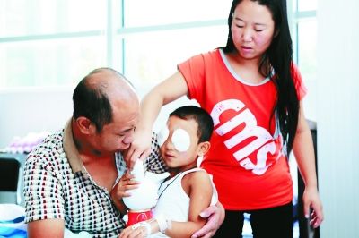 斌斌手術(shù)后第一天恢復(fù)良好，斌斌父母在用玩具逗他開心供圖/嚴(yán)益