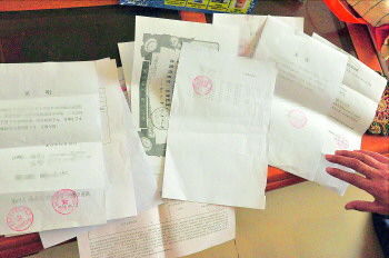 60歲的市民仇先生為了辦理公證所需的這些證明材料,半個月時間里跑了30多趟腿。記者　李萌博　攝