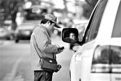 10月15日，朝陽區(qū)東大橋路，停車管理員從腰間掏出一個專用POS機(jī)，正在錄入停車信息。新京報記者 周崗峰 攝