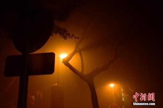 1月31日凌晨，市民行走在煙霧繚繞的南京街頭。當(dāng)天是農(nóng)歷馬年正月初一，南京有限開禁燃放煙花爆竹正逢下霧天，空氣的不流通致使煙花爆竹燃燒后產(chǎn)生的顆粒物不能及時(shí)散開，造成整座城市煙霧繚繞。據(jù)當(dāng)?shù)丨h(huán)保部門發(fā)布的信息顯示，空氣質(zhì)量屬重度污染。中新社發(fā) 泱波 攝