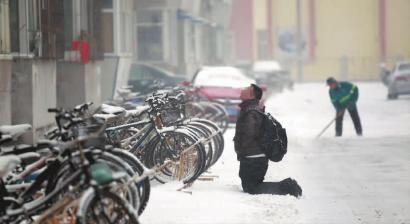 小伙子跪在樓前，一直抬頭看著樓上。 孫立國(guó)/攝