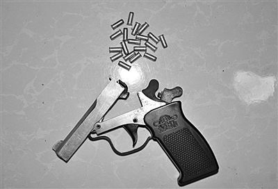 警方從搶劫嫌疑人處起獲的贓款和發(fā)令槍、子彈。警方供圖