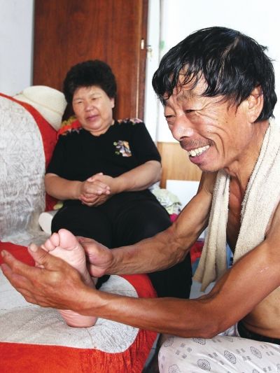 慈成富為老伴按摩。
