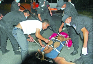 眾人合力將狂犬病發(fā)作的江某控制住。 孫東城 攝