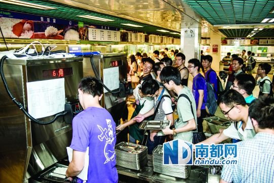 昨日，華南理工大學一食堂內(nèi)，學生們正在使用新安裝的自動打飯機打飯。中新社發(fā)