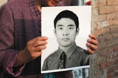 5月19日，朝陽(yáng)北路，母親捧著張東文的遺像。新京報(bào)記者 侯少卿 攝