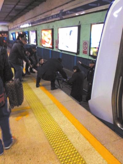 地鐵工作人員將林某從站臺下救起。網(wǎng)友供圖