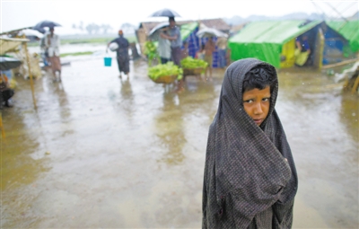 5月14日，緬甸若開(kāi)邦實(shí)兌難民營(yíng)，羅興亞族難民在雨中行走。熱帶風(fēng)暴“馬哈森”即將登陸緬甸，這里的難民開(kāi)始乘船撤離。