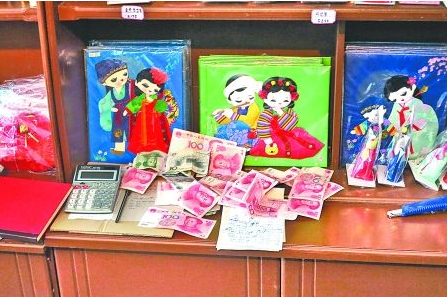 　　2012年6月21日，在朝鮮羅先特別市的一家商店里，柜臺(tái)上散落著一些人民幣。在朝鮮，人民幣比本國(guó)