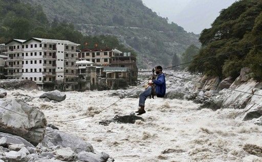 一名印度男子靠繩索渡河。
