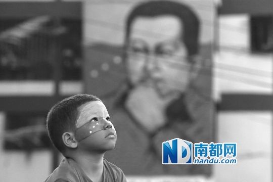 3月5日，一名委內(nèi)瑞拉兒童仰望天空，他身后是查韋斯的陵墓。